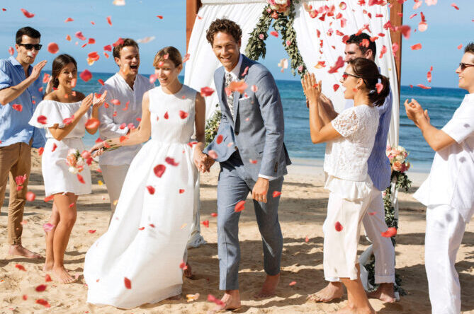 Group of people celebrating the newly wed couple on the beach