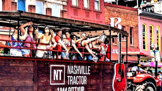 Group of women riding on the Nashville Tractor wagon through downtown.