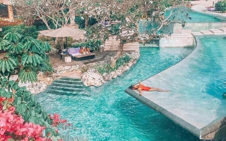 Couple lounging around a tropical pool at a resort